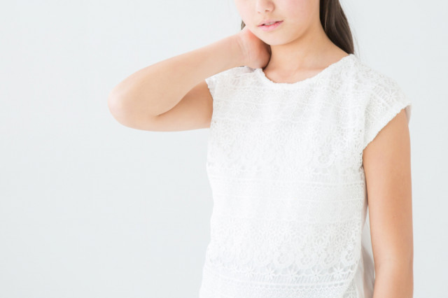 首を抑える女性の写真